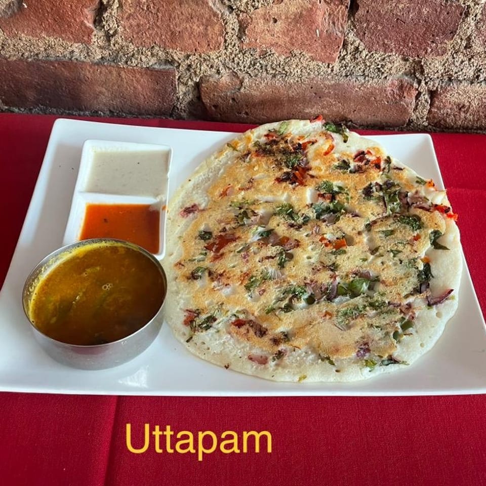 Jalsa's Uttapam, a savory Indian pancake with vegetables, served with two chutneys and sambar.